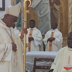 Obispo con mitra y báculo dorado, revestido de casulla blanca, junto a varios sacerdotes ante el altar durante la homilía de independencia en Guinea Ecuatorial