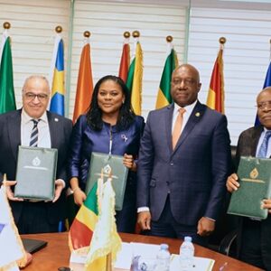 Cérémonie de signature des protocoles du projet CAPS le 29 septembre 2026 à Brazzaville : de gauche à droite, Baltasar Engonga Edjo'o (CEMAC), Nathalie Lum (CABEF), Farid Ghezali (APPO) et un représentant, présentant les documents signés devant les drapeaux d'Afrique centrale.