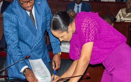 Benita Ebang Nzang, vestida de fucsia, firma un acta en la Sala Plenaria del Ministerio de Hacienda en Malabo durante su toma de posesión de 2024
