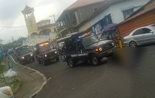 Columna de vehículos de la Gendarmería Nacional con las luces encendidas recorre una calle de Baney, al norte de la isla de Bioko